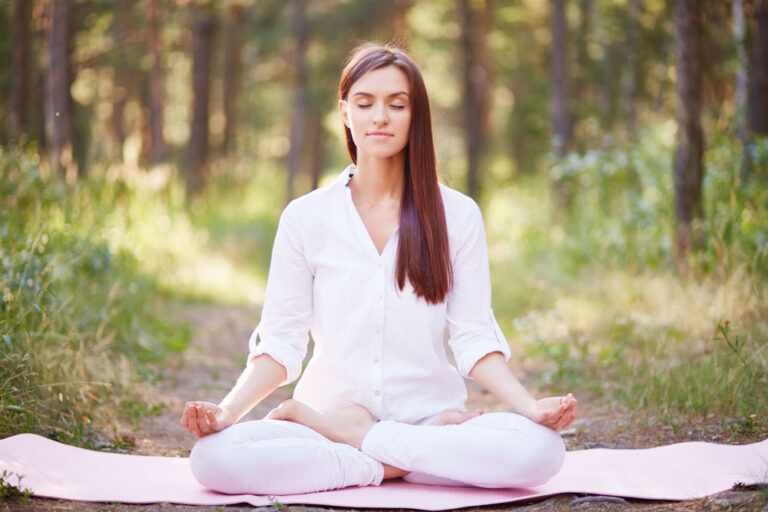 Beautiful woman meditating in nature